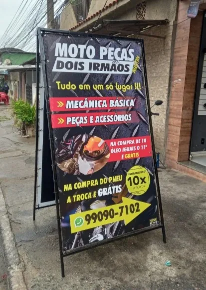 Cavalete de ferro dupla face na calçada de uma loja de motopeças