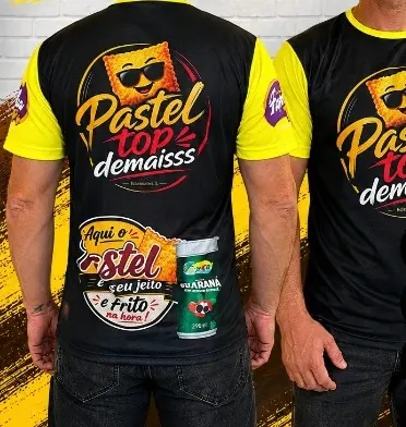 Camisas de uniforme pretas e amarelas com estampa sublimada de uma pastelaria, produzidas pela Flamagraf